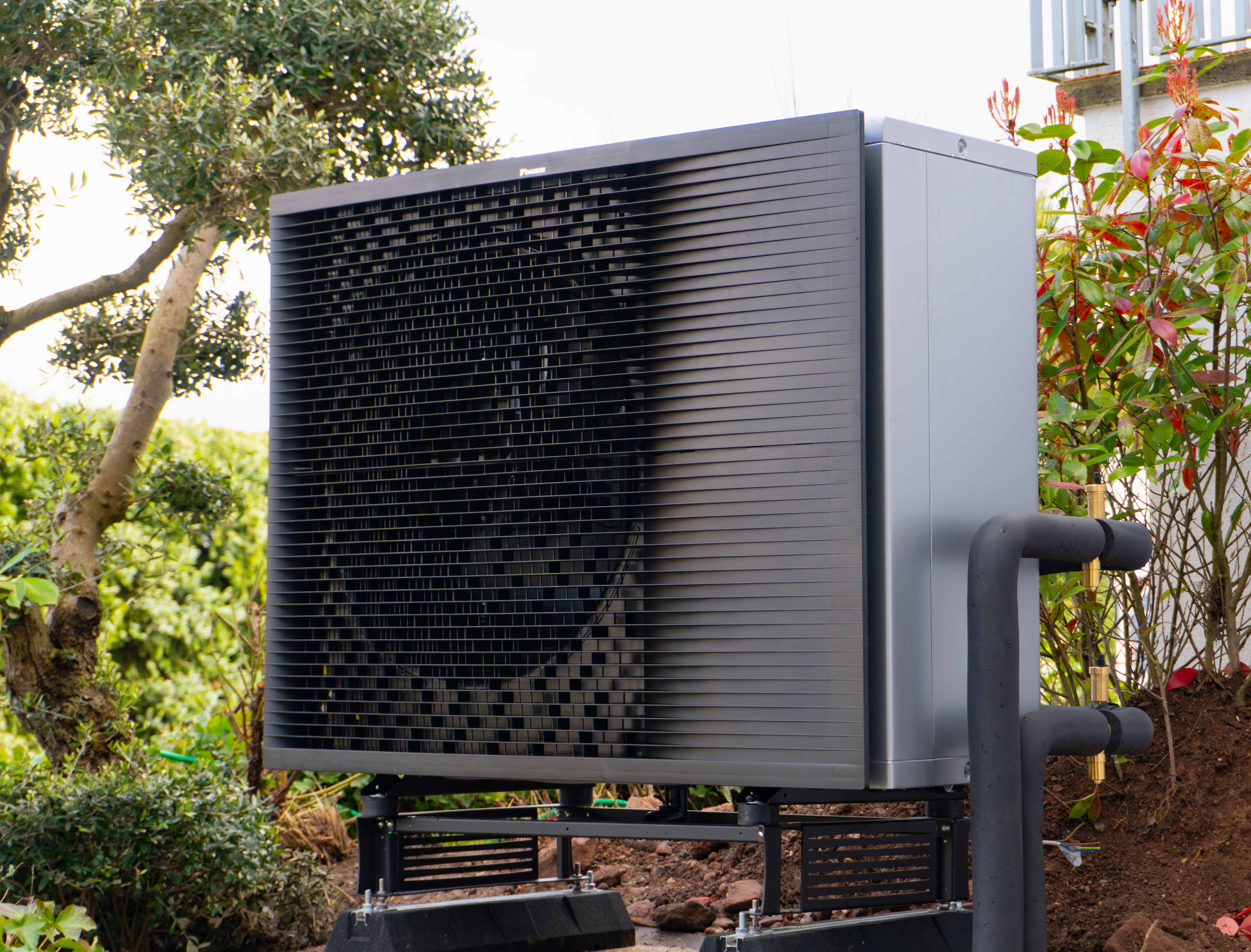 Moderne Wärmepumpe vor einem Haus